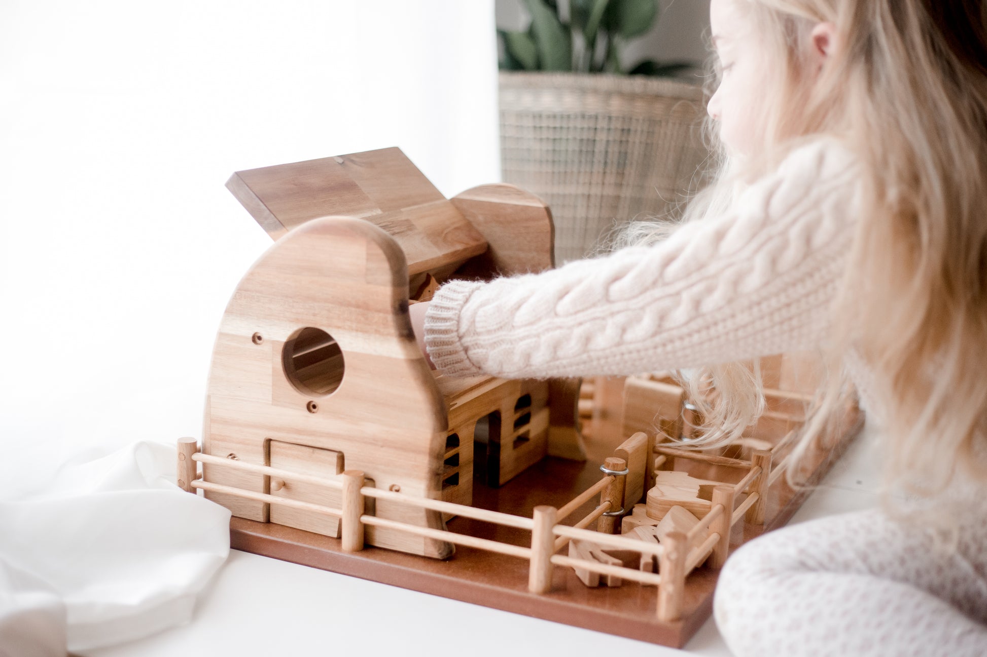 Children play with the beautifully crafted Farm Barn, inspiring imaginative rural adventures with toy animals and tractors.